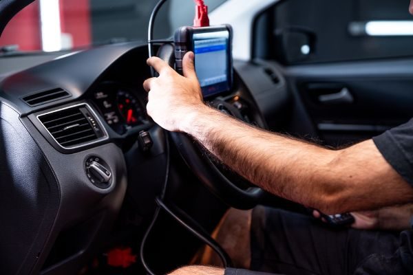 a mechanic running a auto diagnostics test on a vehicle